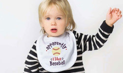 White baby bib with "apparently I like Baseball" text and a yellow baseball graphic.