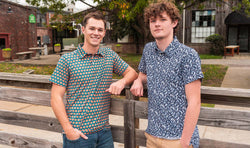 Two young teens modeling patterned short-sleeve basketball polo shirts.