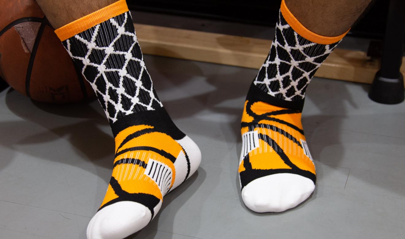 Basketball crew socks with a black and white net pattern and orange basketball graphic