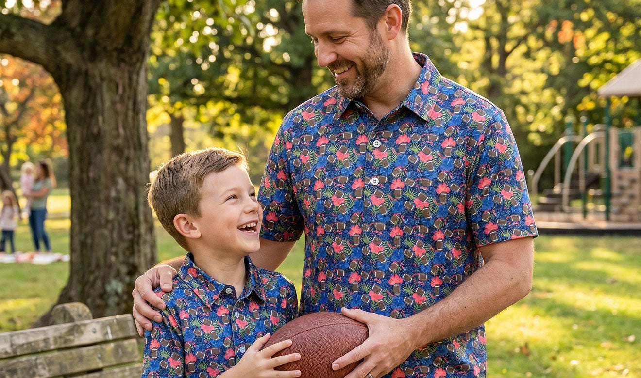Man and child in matching floral polo shirts holding a football outdoors