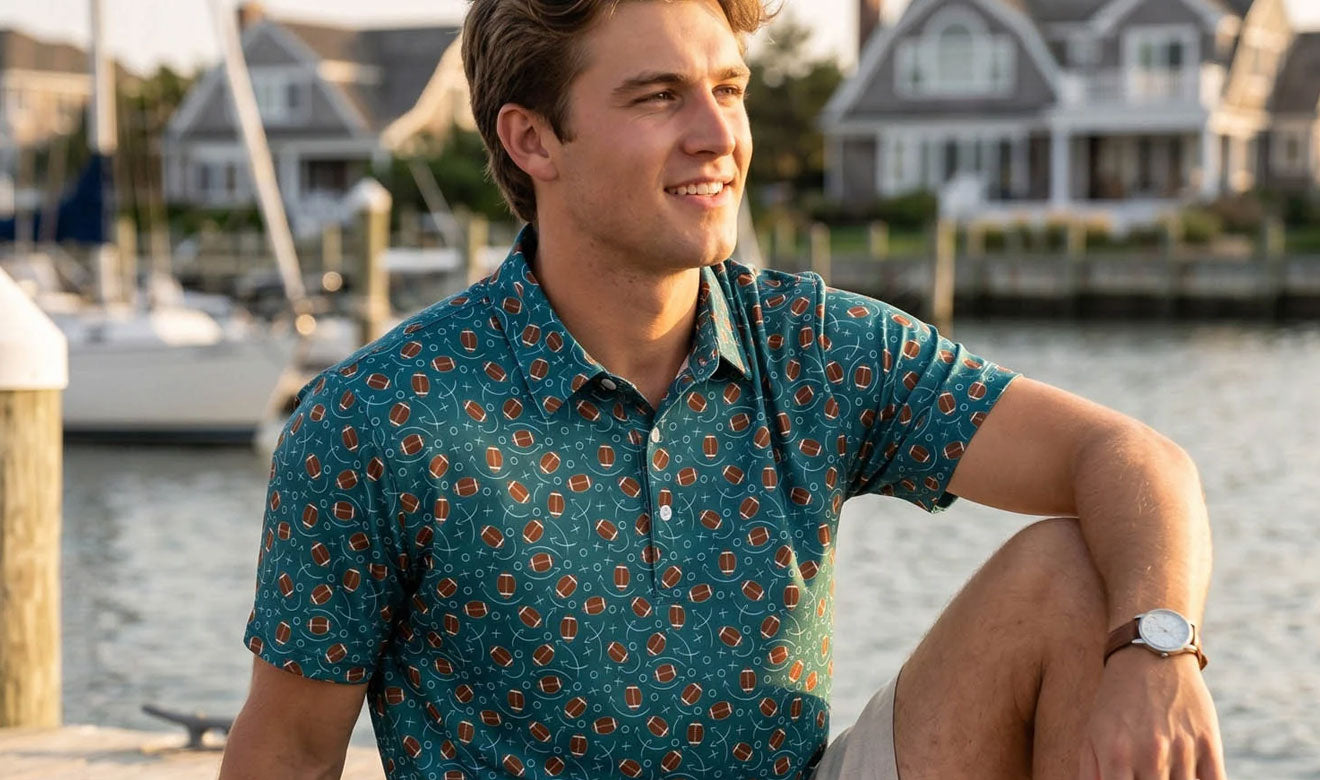 Teen wearing a football polo sitting by a waterfront with houses and boats in the background