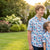 Family of four wearing matching blue hockey patterned shirts standing outdoors in a garden.