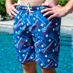 Model wearing blue lacrosse shorts featuring white stars and a red and light blue lacrosse stick pattern.