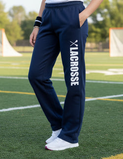 Model wearing navy blue lacrosse sweatpants featuring vertical white Lacrosse text and stick graphic on leg.
