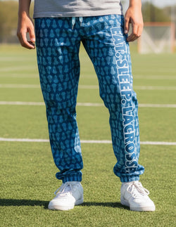 Blue lacrosse lounge pants featuring stick head pattern and white Eat Sleep Lacrosse text on leg.
