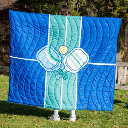 Blue pickleball blanket featuring large crossed paddles and ball graphic.