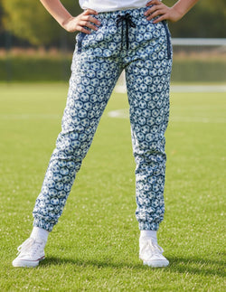 Youth wearing soccer lounge pants featuring an all-over blue and white soccer ball pattern.