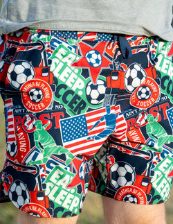 Colorful shorts with soccer-themed graphics and text on a grassy background
