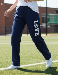 Navy blue soccer sweatpants featuring large vertical white Love text with a soccer ball graphic.