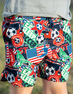 Colorful shorts with soccer-themed graphics and text on a blurred background