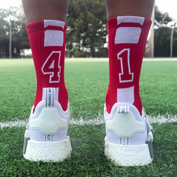 Red custom number soccer socks featuring large white digits on the back of the leg.