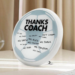Round soccer plaque with 'Thanks Coach' text and signatures on a white surface.