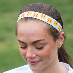 Girl wearing white softball headband featuring a repeating pattern of yellow heart-shaped softballs.