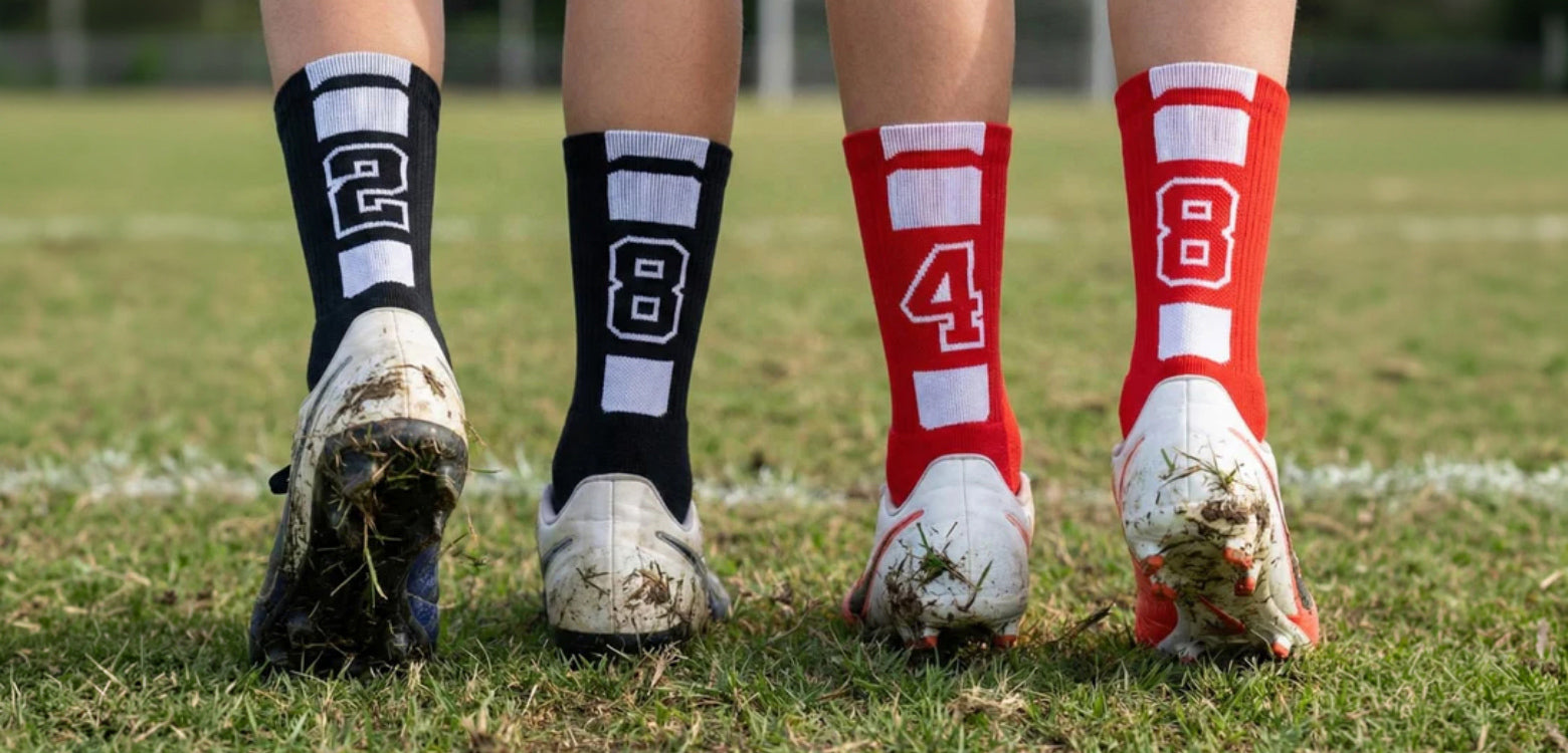 Soccer cleats and socks with numbers on a grass field