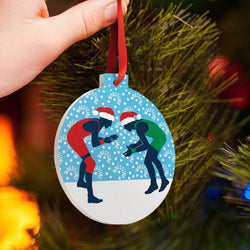 Wrestling Christmas ornament with a graphic of two wrestlers wearing Santa hats on a blue snowy background.