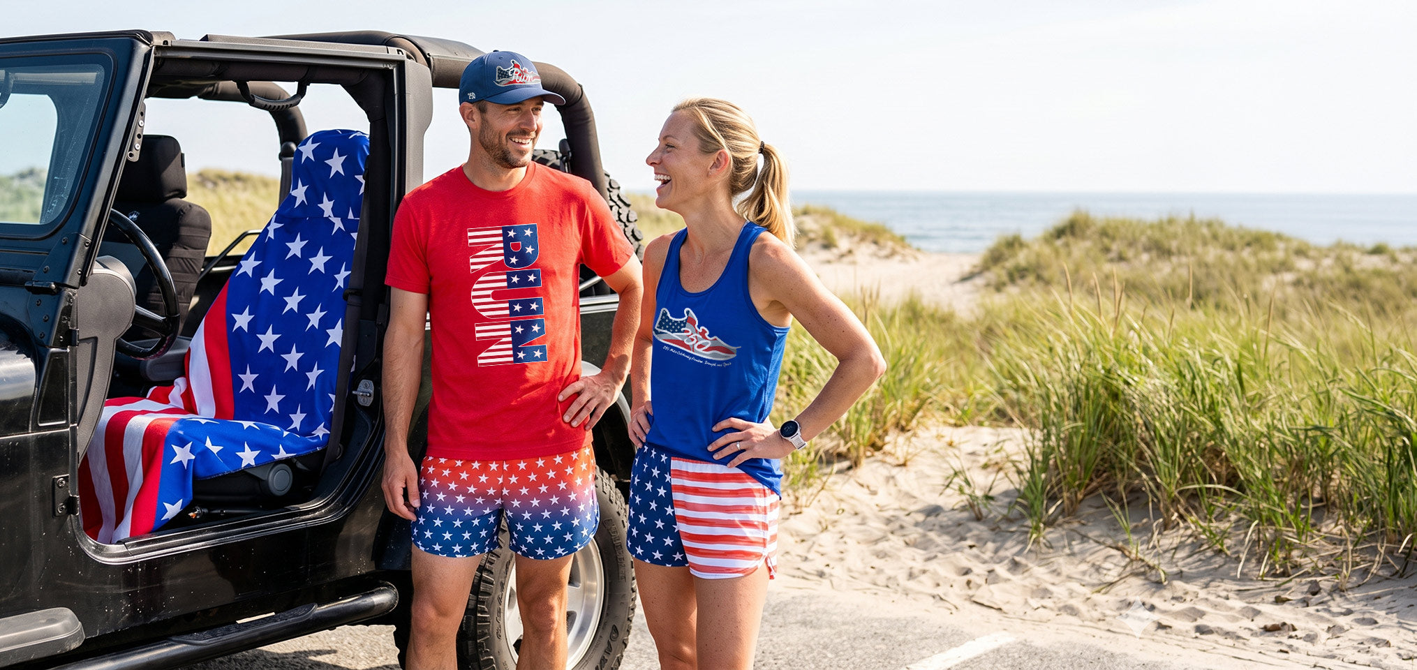 Two people in patriotic-themed outfits standing next to an open car door with a beach and ocean in the background.