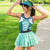 Woman in a St. Patrick's Day running outfit with shamrock visor, corset-style tank top, and green tutu.