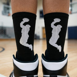Black socks with white basketball graphic on a blurred indoor background