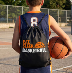 Person wearing a basketball jersey with number 8, holding a basketball, and carrying a 'Eat. Sleep. Basketball. backpack