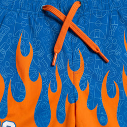 Blue basketball shorts with orange flames and orange drawstring on a blue background with white graphics.