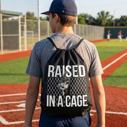 Teen wearing a baseball drawstring backpack with Raided In A Cage design on a baseball field.