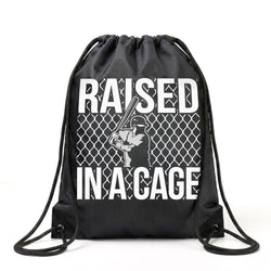 Black drawstring bag with 'Raised in a Cage' text and graphic on a white background