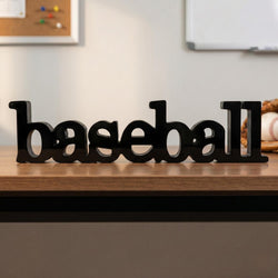 Black 'baseball' sign on a wooden surface with sports-themed decor in the background.