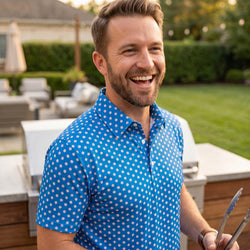 Man wearing baseball patterned polo shirt outdoors at a bbq.