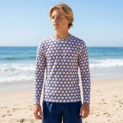 Person wearing a baseball patterned long-sleeve rashguard shirt on a beach