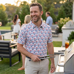 Man wearing a patriotic baseball patterned polo shirt outdoors at a bbq.