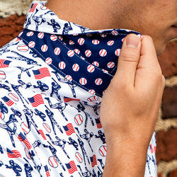 Close-up of a person wearing a patterned polo shirt with baseball-themed design.
