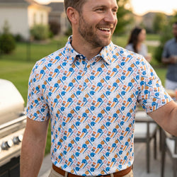 Man wearing a baseball patterned polo shirt outdoors at a bbq