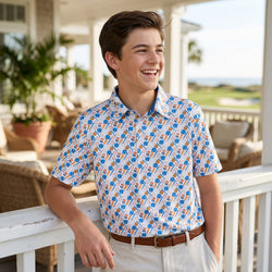 Young man wearing a baseball patterned shirt on a porch with plants and furniture in the background