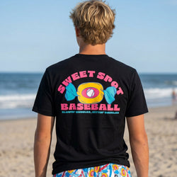 Teenage boy wearing a black t-shirt with 'Sweet Spot Baseball' design on a beach