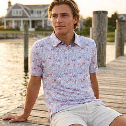 Person wearing a patriotic patterned baseball polo shirt outdoors on a pier.