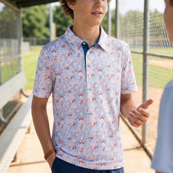Person wearing a patriotic patterned baseball polo shirt in a dugout.
