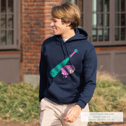 Person wearing a navy hoodie with a colorful graphic of a baseball bat and donut outdoors.