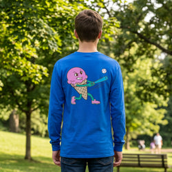 Person wearing a blue long-sleeve shirt with a colorful ice cream baseball graphic on the back, standing in a park.