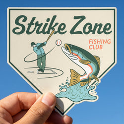 Sticker with 'Strike Zone Fishing Club' design featuring a fish and a person with a fishing rod against a blue sky.