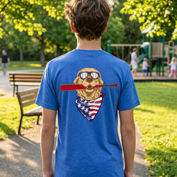 Person wearing a blue t-shirt with a baseball dog graphic design in a park