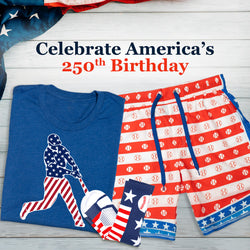 Blue t-shirt with American flag design, red shorts with baseball pattern, and blue socks on a wooden surface with text 'Celebrate America's 250th Birthday'.