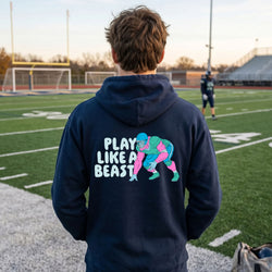 Person wearing a hoodie with a football graphic and text on a football field