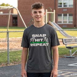 Person wearing a t-shirt with a football-themed graphic and text on a playground background