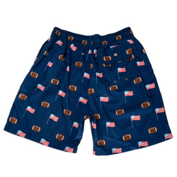 Navy blue swim shorts with football and flag pattern on a white background