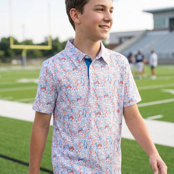 Person wearing a football polo shirt with patriotic pattern on a football field.