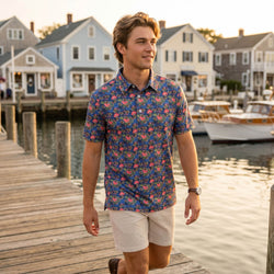 Teen wearing a tropical football themed polo shirt outdoors at a pier.