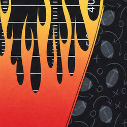 Close-up of a printed fabric or surface design with black, yellow, orange, and red flame shapes over a football-field-style background, plus gray football motifs on a dark patterned section.