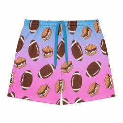 A pair of shorts featuring a blue-to-pink gradient background with a repeating pattern of brown footballs and graham cracker s'mores, complete with a blue drawstring waist.