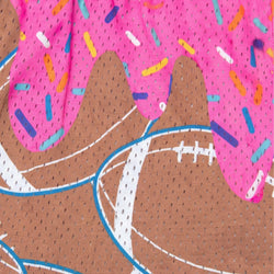 A close-up of a pink mesh fabric printed with a donut pattern, featuring brown dough, pink frosting with colorful sprinkles, and a football graphic outlined in blue.