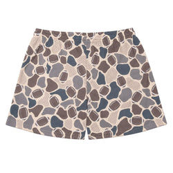 A pair of athletic shorts featuring an all-over abstract pattern of footballs in brown, slate blue, and gray over a beige mesh-like background.
